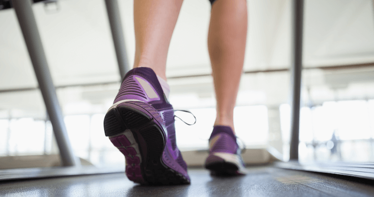 Female Leg and Feet Walking on a Treadmill in Fitness Center